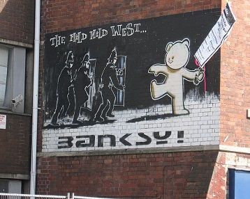 Banksy's first known mural, <i>The Mild Mild West</i> (1997), depicting a teddy bear lobbing a Molotov cocktail at three police officers